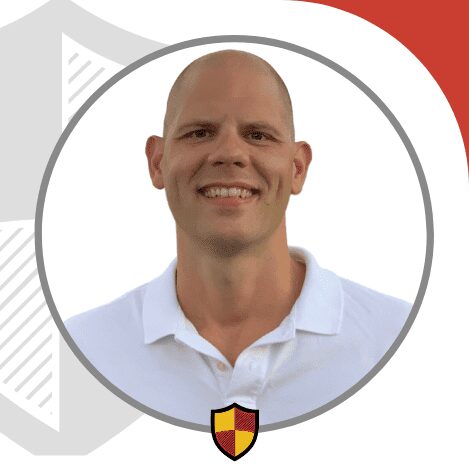 A smiling bald man in a white polo shirt.