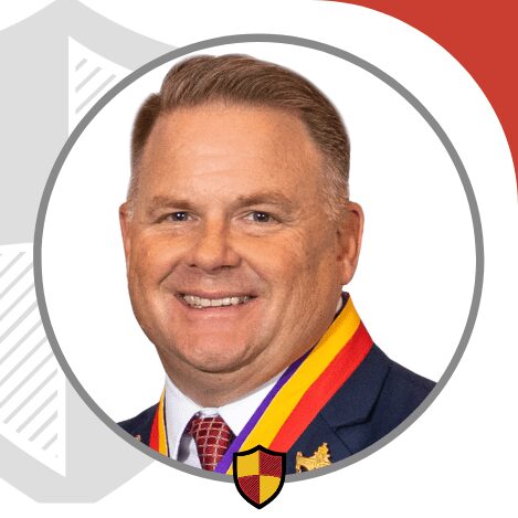 Portrait of a smiling man in formal attire with a medal.