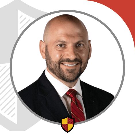 Professional portrait of a man in a suit and red tie.