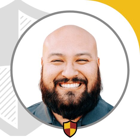 A smiling bald man with a beard in a circular frame.