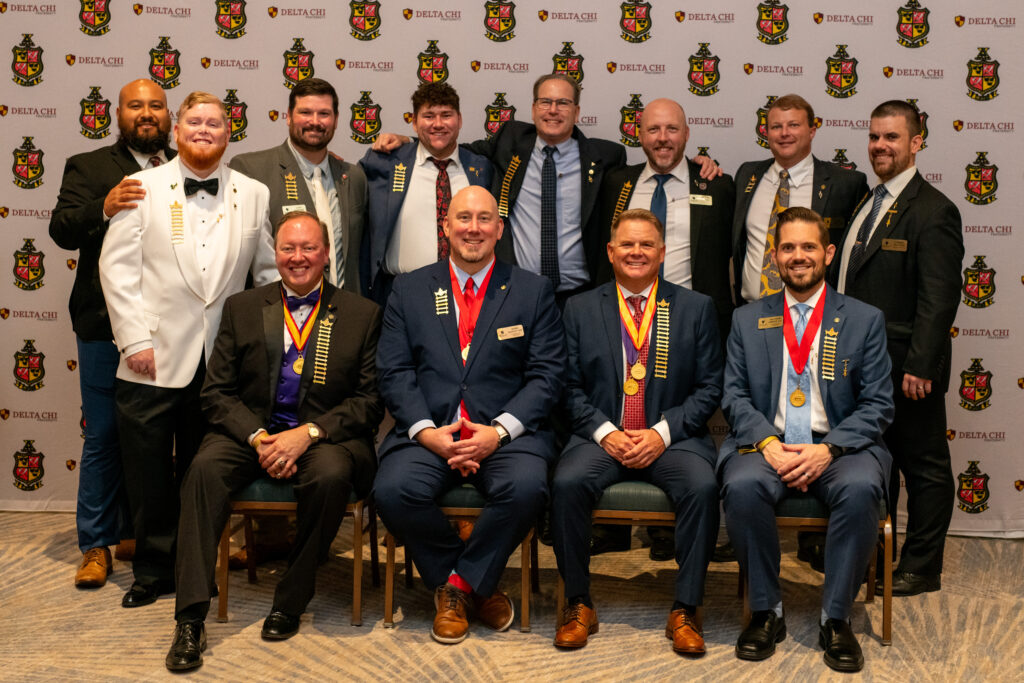 Group of men in formal attire, smiling.