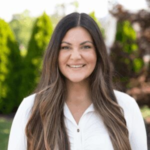 Smiling woman outdoors with long hair.