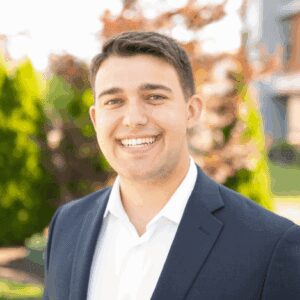 Smiling man in suit outdoors.