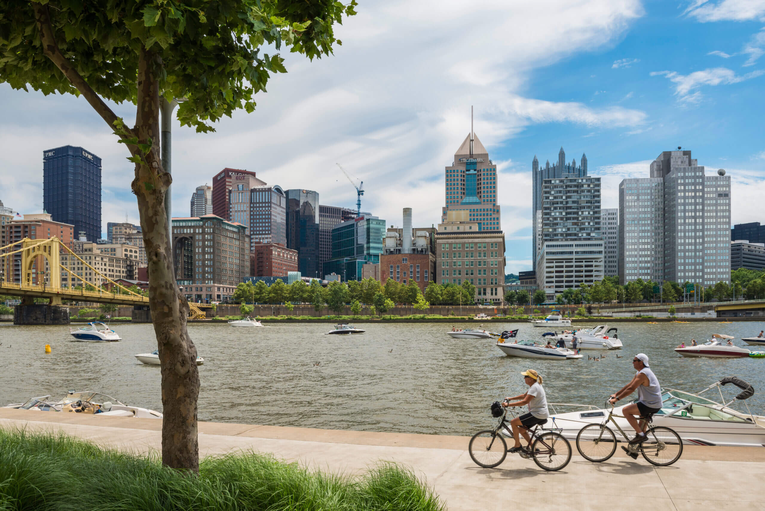 Pittsburgh riverfront skyline with cyclists and boats